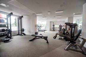 Surrey condo for rent - A gym with a variety of equipment including weights and machines.