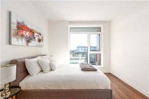 Vancouver condo for rent - A bedroom with a large bed and a painting on the wall.