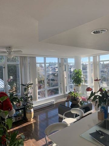 Vancouver condo for rent - A kitchen with a table and chairs and a window with a view of the city.