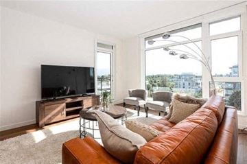 Vancouver condo for rent - A living room with a brown leather couch and a flat screen TV.