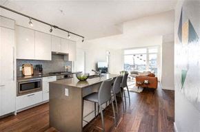 Vancouver condo for rent - A modern kitchen with a dining table and chairs.
