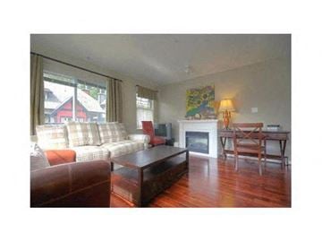 Vancouver townhouse for rent - A living room with a fireplace and a painting on the wall.