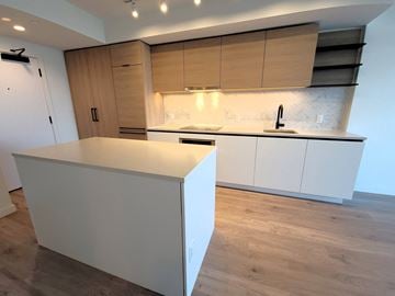 Surrey condo for rent - A kitchen with a white counter and wooden cabinets.