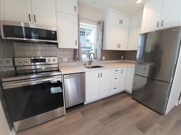 Vancouver apartment for rent - A kitchen with white cabinets and stainless steel appliances.