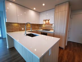 Burnaby apartment for rent - A modern kitchen with a white countertop and wooden cabinets.