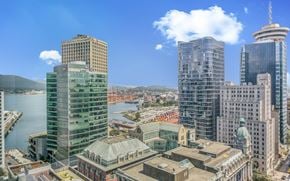 Vancouver apartment for rent - A cityscape with a large body of water in the foreground and several tall buildings in the background.