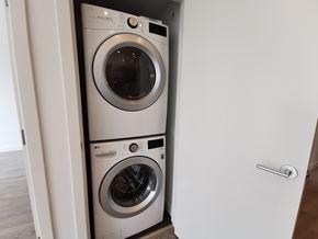 Burnaby condo for rent - Two washing machines are stacked in a small space.