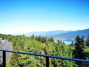 Burnaby condo for rent - A view of a highway with trees and mountains in the distance.