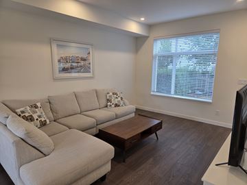 Mission townhouse for rent - A living room with a large couch and a coffee table.