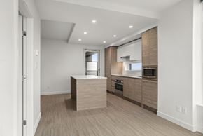 Surrey condo for rent - A modern kitchen with wooden cabinets and a central island.