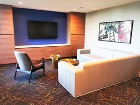 Burnaby condo for rent - A living room with a white couch, a chair, and a television.