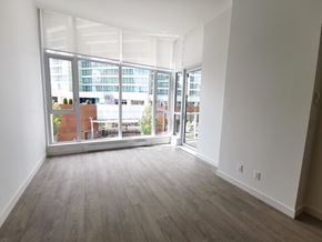 Burnaby condo for rent - A room with a view of a cityscape through large windows.