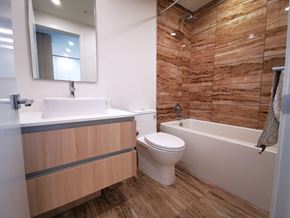 Burnaby apartment for rent - A bathroom with a wooden wall and a white toilet.