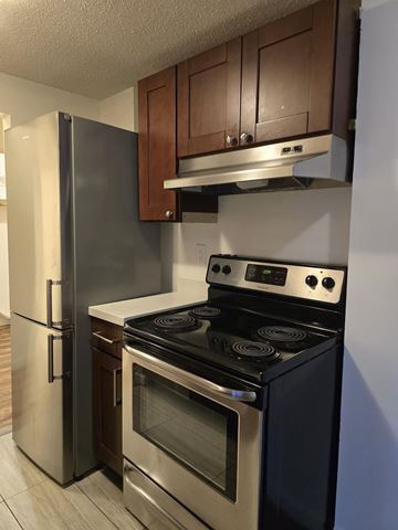 Vancouver apartment for rent - A modern kitchen with a stainless steel refrigerator and oven.