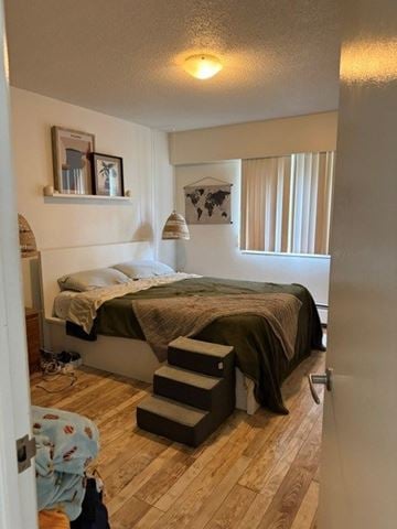 Vancouver apartment for rent - A bedroom with a bed, a staircase, and a picture on the wall.