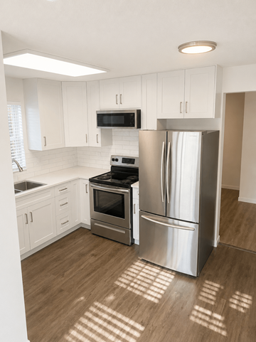 Coquitlam apartment for rent - A kitchen with a refrigerator, oven, and microwave.