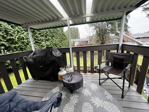 Maple Ridge apartment for rent - A patio with a black bag and a white jug on it.