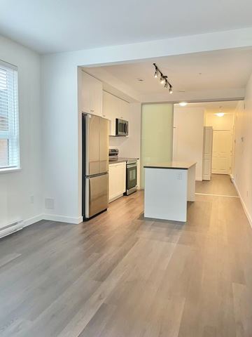 Surrey condo for rent - A kitchen with a white refrigerator and a white island.