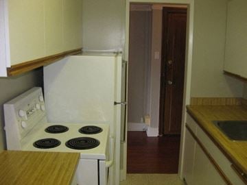 Vancouver apartment for rent - A white stove in a kitchen with a wooden counter top.