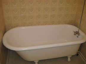 Vancouver apartment for rent - A white bathtub with a silver faucet is in a bathroom with a tiled wall.