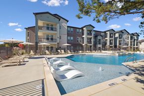 Denton apartment for rent - A large swimming pool in front of apartment buildings.