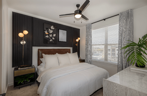 Round Rock apartment for rent - A bedroom with a large bed and a ceiling fan.