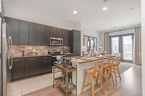 Broomfield apartment for rent - A modern kitchen with dark wood cabinets and a central island  at Bridges at Flatiron, Broomfield, 80021