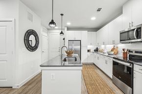 Denton apartment for rent - A modern kitchen with white cabinets and stainless steel appliances.