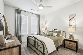 Denton apartment for rent - A bedroom with a bed, nightstand, and a painting on the wall.