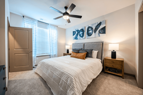 Antioch apartment for rent - A bedroom with a large bed, a ceiling fan, and a painting on the wall.