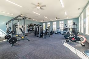 Charlotte apartment for rent - A spacious gym with a variety of equipment including treadmills, weights, and exercise bikes.