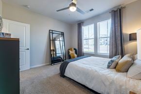 Charlotte apartment for rent - A bedroom with a large bed and a ceiling fan.