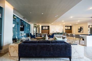 Charlotte apartment for rent - A modern living room with a dark blue sofa and a marble coffee table.