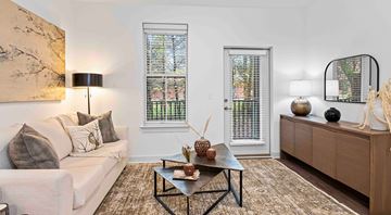 Arden apartment for rent - A living room with a white couch, a coffee table, and a large painting on the wall.