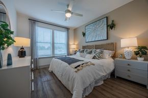Ruskin apartment for rent - A bedroom with a large bed, a ceiling fan, and a painting on the wall.