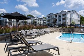 Raleigh apartment for rent - A pool area with sun loungers and a black umbrella.