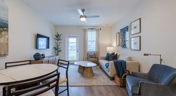 Charlottesville apartment for rent - A living room with a white ceiling fan and a painting on the wall.