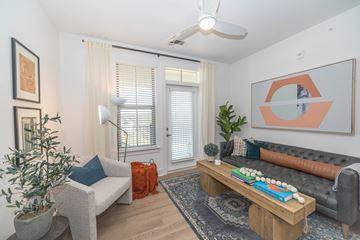 Fort Mill apartment for rent - A living room with a grey couch, a wooden coffee table, and a painting on the wall.