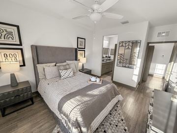 Gainesville townhouse for rent - A bedroom with a large bed and a ceiling fan.
