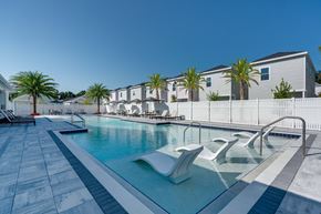 Gainesville townhouse for rent - A pool with a white fence and palm trees in the background.