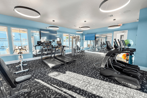 Gainesville townhouse for rent - A gym with a variety of equipment including treadmills, weights, and exercise machines.
