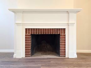 Harrisburg apartment for rent - A white fireplace with a brick interior and a wooden mantle.