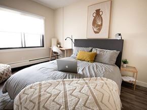 Edmonton apartment for rent - a bedroom with a bed with a laptop on it