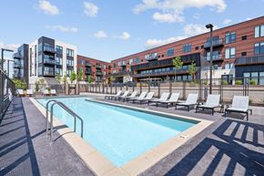 Shoreview apartment for rent - A swimming pool surrounded by lounge chairs and apartment buildings.