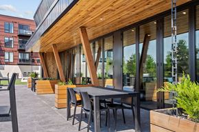 Shoreview apartment for rent - A modern outdoor dining area with a wooden table and chairs.