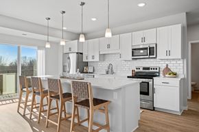Waconia apartment for rent - a kitchen with white cabinets and a white island with chairs