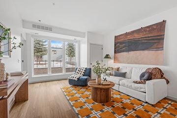 Eden Prairie apartment for rent - A living room with a white couch, a coffee table, and a large painting on the wall.