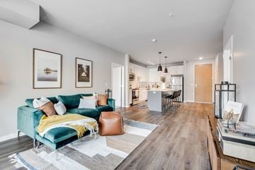 Champlin apartment for rent - a living room with a green couch and a kitchen with a dining room