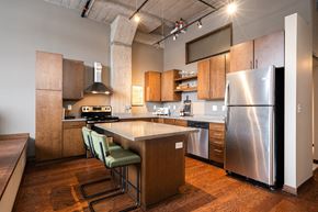 Minneapolis apartment for rent - A kitchen with a stainless steel refrigerator and wooden floors.