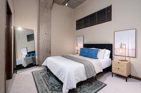 Minneapolis apartment for rent - A bedroom with a large bed and a mirror on the wall.